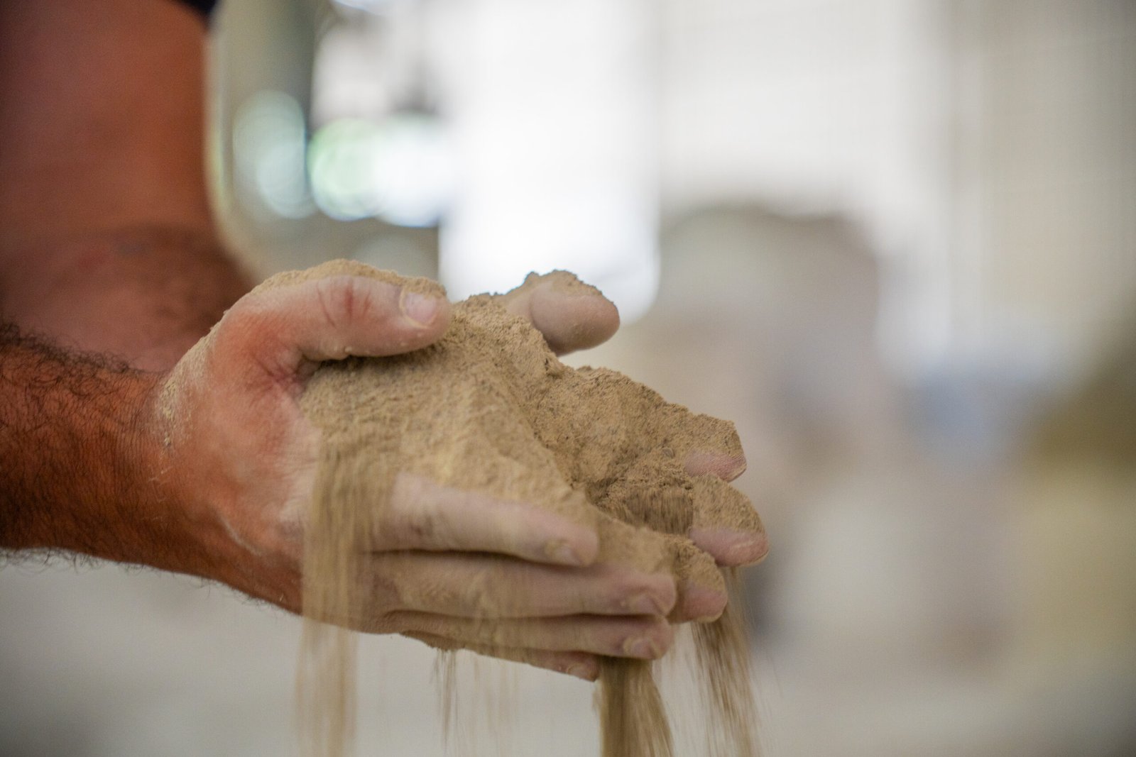 A imagem mostra as duas mãos de um homem segurando fertilizante mineral simples.